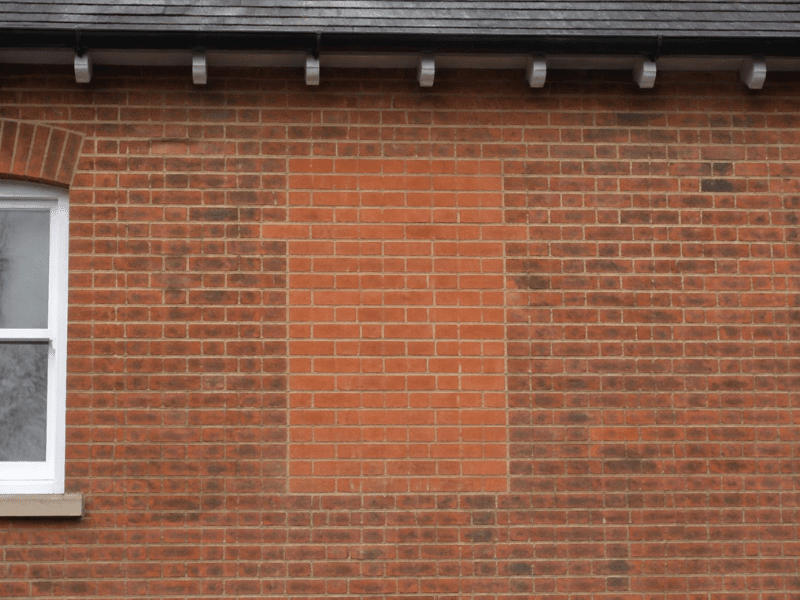 Bricked-up window opening with mismatched new bricks before tinting