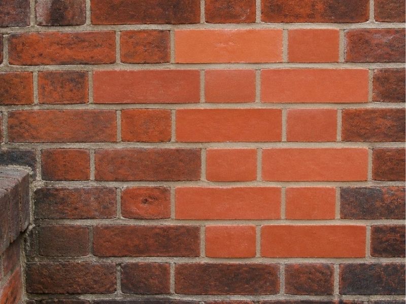 New replacement bricks being individually tinted to match older brickwork