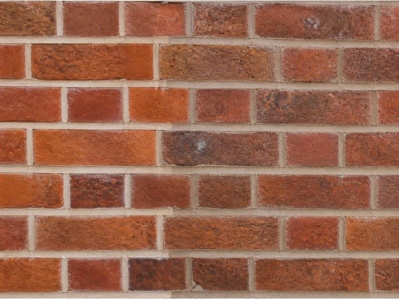 Bright new mortar joints beside tinted joints matched to older mortar