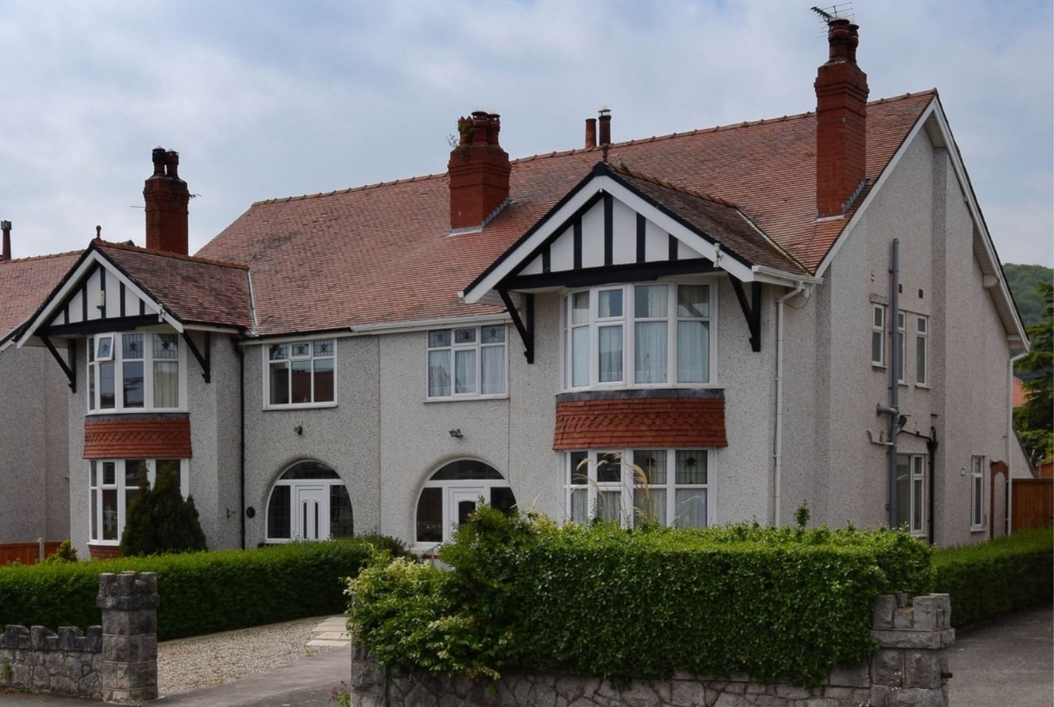 Rendered 1930s semi-detached house with a freshly applied off-white external wall coating.