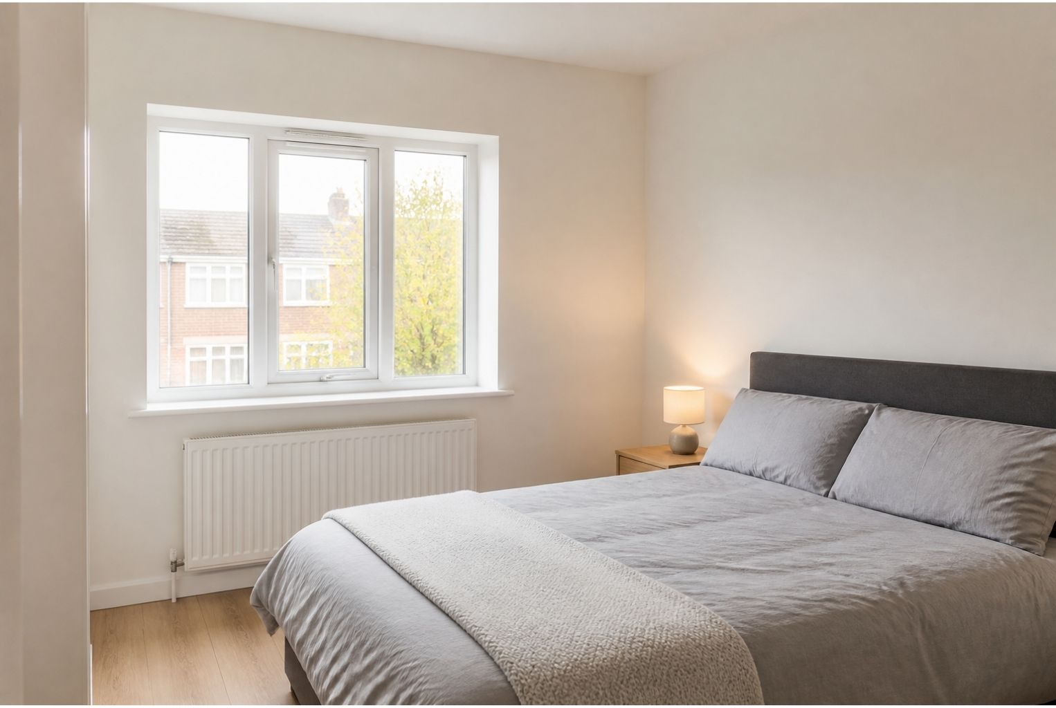 Freshly redecorated rental flat bedroom with clean, mould-free walls around the window.